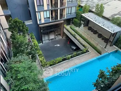 Modern apartment building with pool and lush greenery, offering a luxurious urban lifestyle.