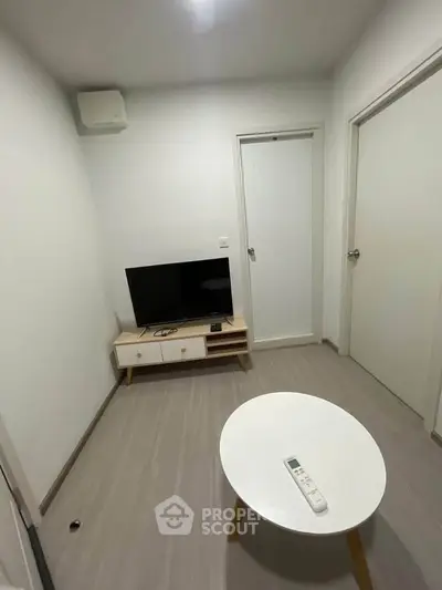 Cozy minimalist living room with modern TV setup and sleek furniture.