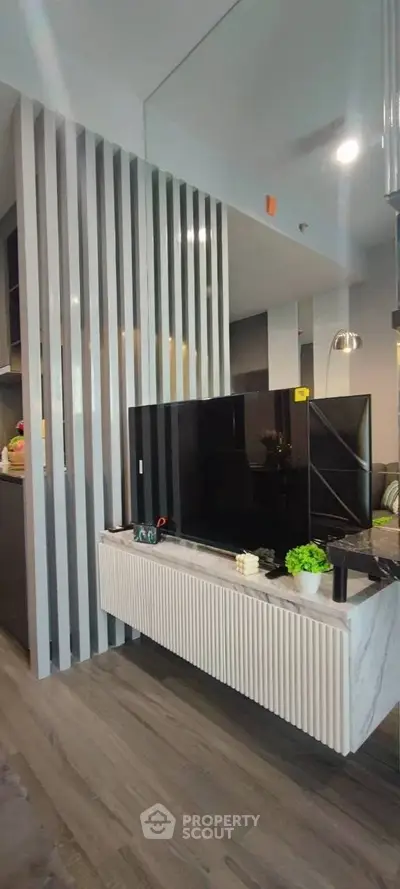 Modern living room with sleek TV unit and stylish decor in contemporary apartment.