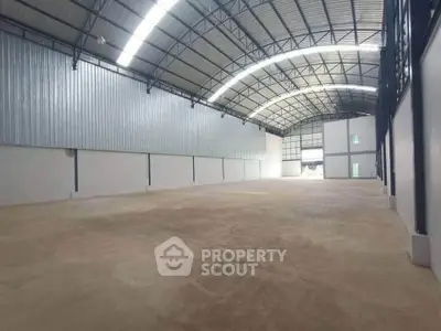 Spacious industrial warehouse with high ceilings and ample natural light, perfect for storage or manufacturing.