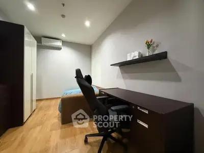 Modern bedroom with sleek desk and comfortable chair, perfect for work and relaxation.