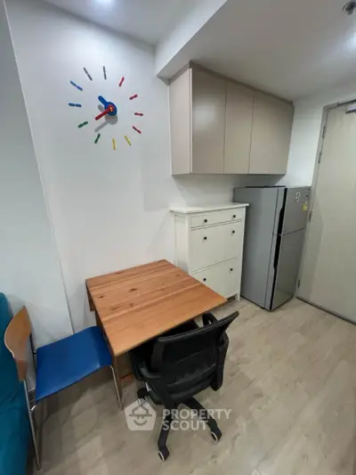 Compact study area with modern decor and kitchen appliances in a cozy apartment.