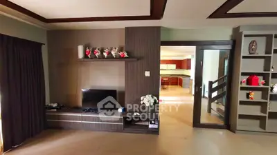 Spacious living room with modern entertainment center and open kitchen view