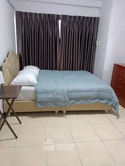 Cozy bedroom with double bed and elegant curtains in a modern apartment.