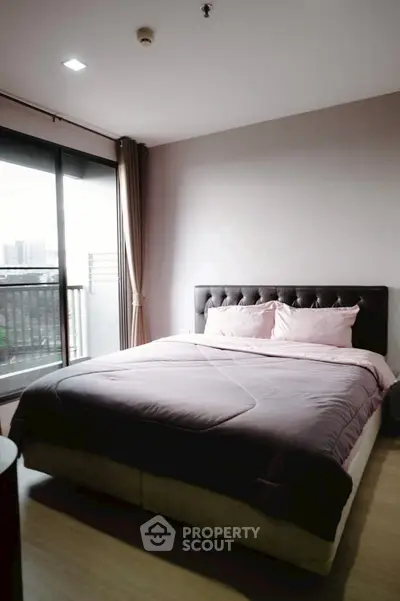 Modern bedroom with large window and balcony view in stylish apartment.