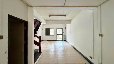 Spacious interior with tiled flooring and staircase, ideal for customization.
