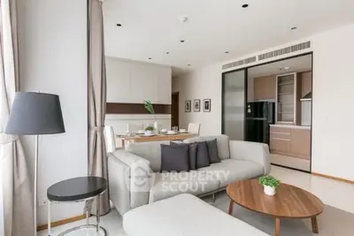 Modern living room with open kitchen, stylish furniture, and elegant decor in a contemporary apartment.