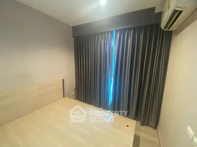 Modern bedroom with sleek design and air conditioning, featuring elegant curtains and minimalist decor.