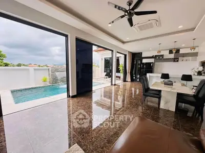Luxurious open-plan living room with pool view and modern kitchen