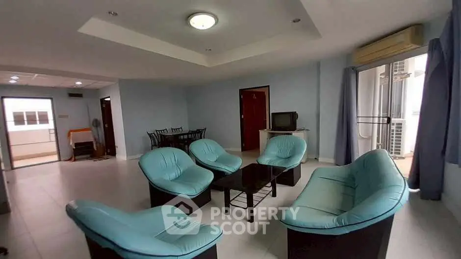 Spacious living room with modern blue seating and natural light