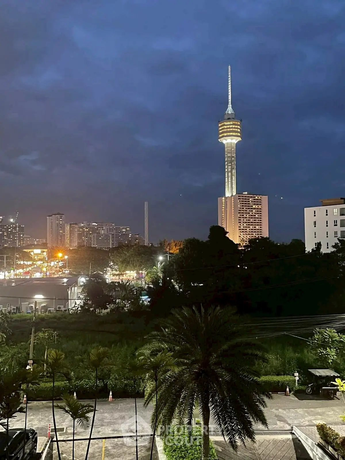 Stunning cityscape view with iconic tower and lush greenery at dusk.