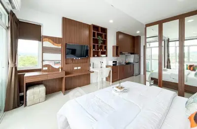 Modern studio apartment with sleek wooden finishes and large windows offering scenic views.