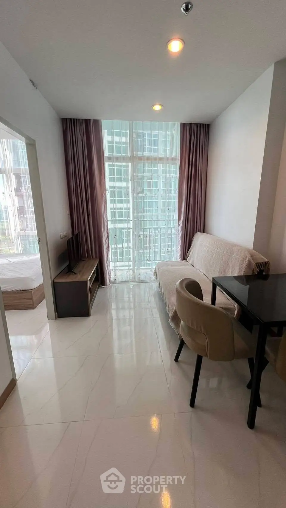 Modern living room with large windows and cozy furniture in a stylish apartment.