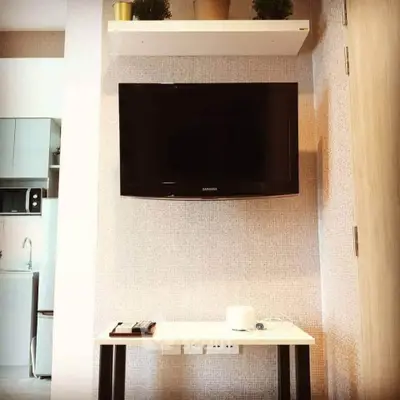 Modern living room with wall-mounted TV and sleek furniture in a stylish apartment.
