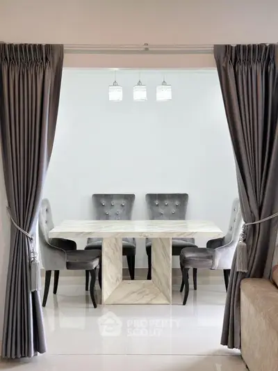 Elegant dining area with marble table and plush chairs, framed by luxurious curtains.