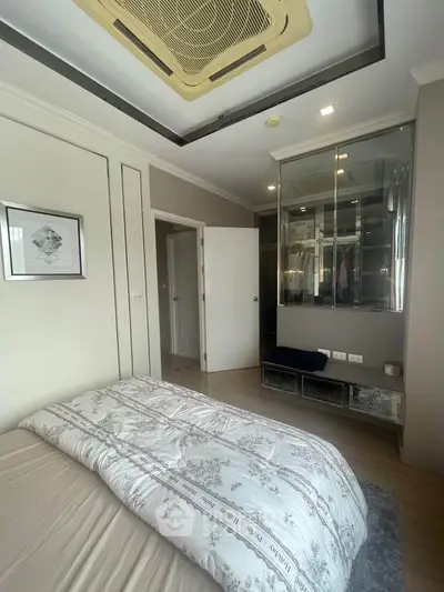 Cozy bedroom with elegant decor and mirrored wardrobe in modern apartment.
