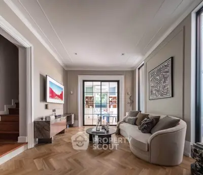 Elegant living room with modern decor and stylish furniture, featuring a cozy sofa and artistic wall art.