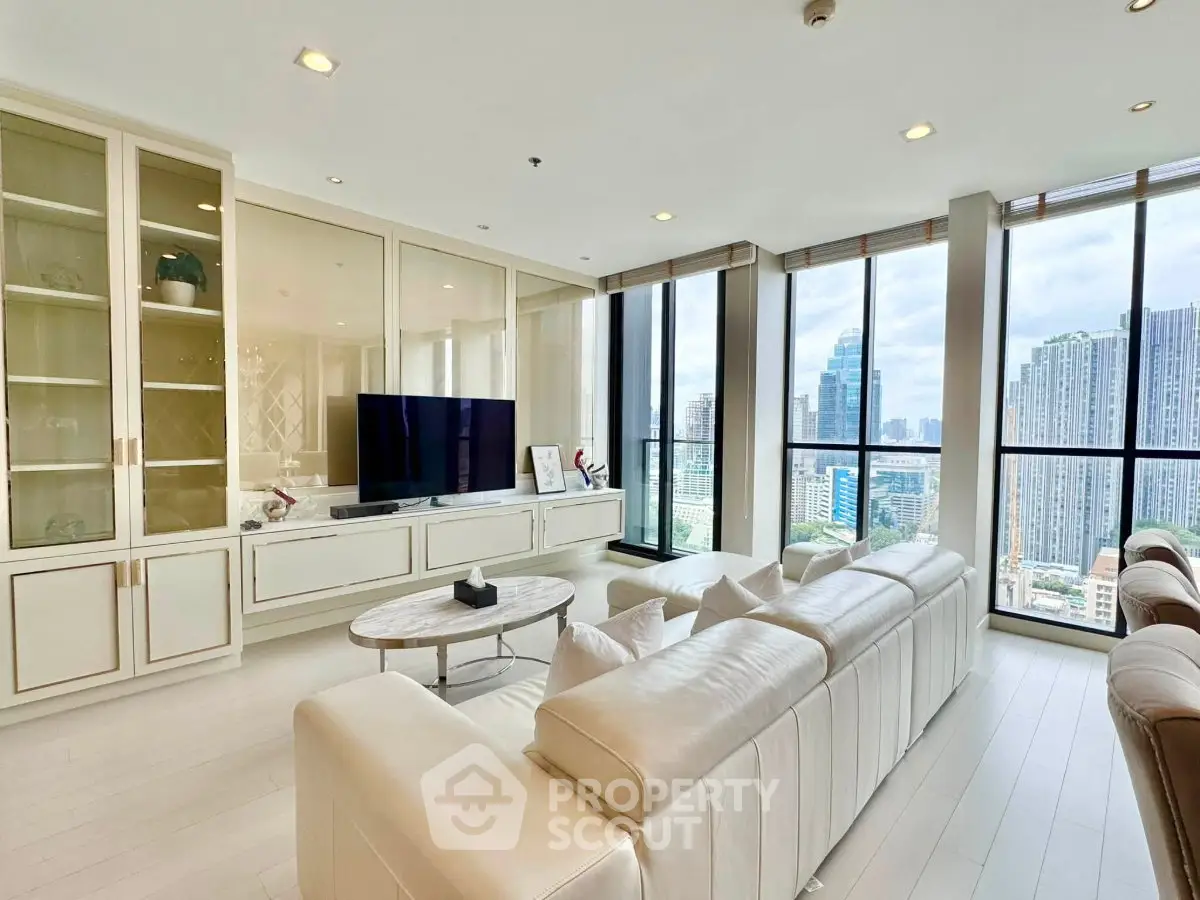 Luxurious living room with panoramic city views and elegant white furnishings.