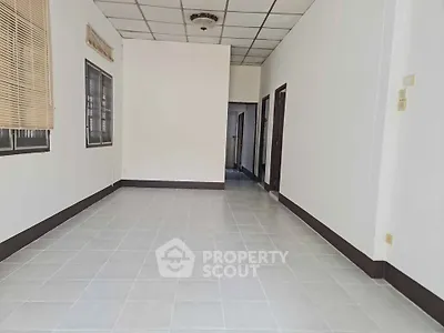 Spacious empty room with tiled flooring and neutral walls, ready for customization.
