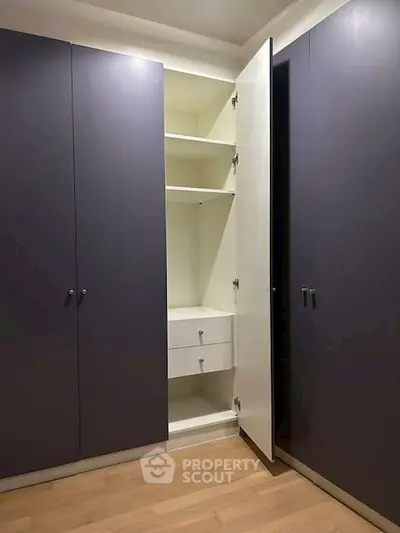 Spacious built-in closet with open shelving and drawers in modern home.