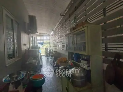 Narrow kitchen space with closed layout and various appliances, ideal for compact living.