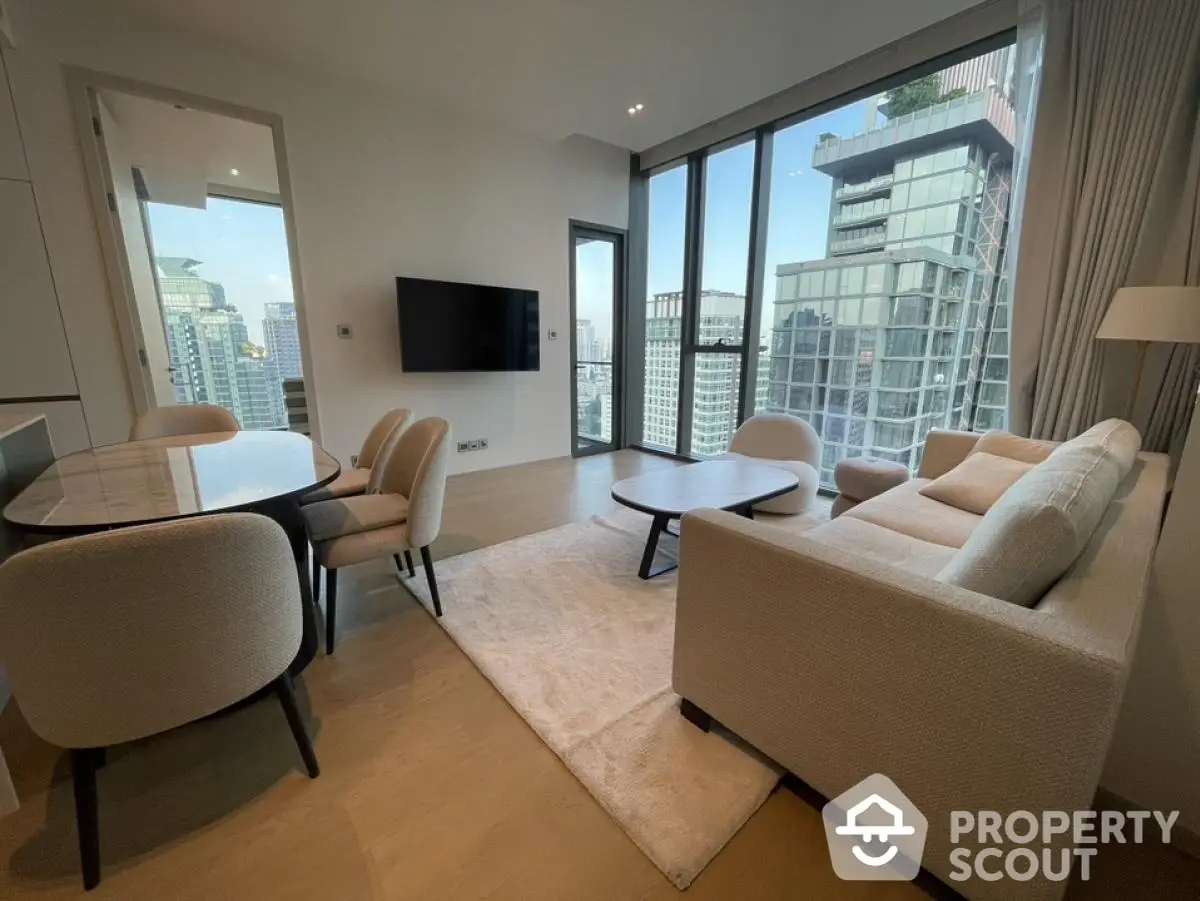 Modern living room with city view, elegant furniture, and floor-to-ceiling windows in a high-rise apartment.