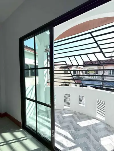 Bright balcony with modern railing and view of neighborhood houses.