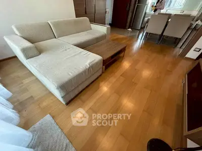 Spacious living room with modern sofa and wooden flooring in a stylish apartment.