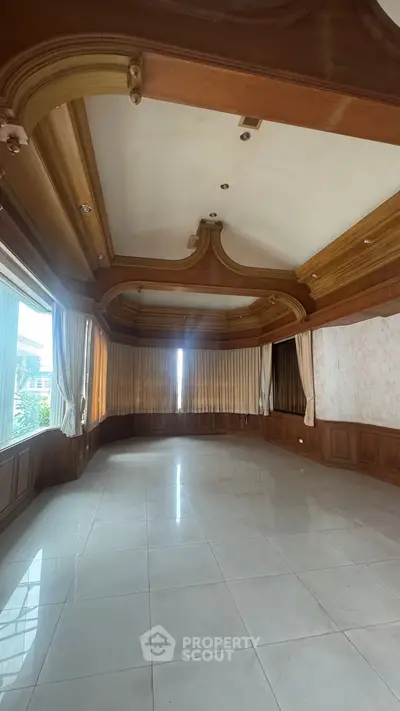Spacious empty living room with elegant wooden ceiling and large windows