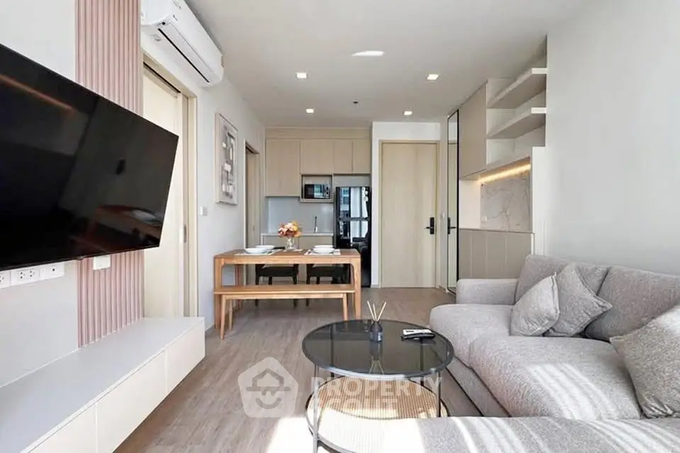 Modern living room with stylish furniture and open kitchen layout in a bright apartment.
