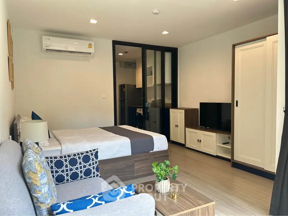 Modern studio apartment with stylish decor, featuring a cozy bed, sleek furniture, and efficient use of space.