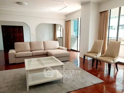 Spacious living room with elegant furniture and large windows in a modern apartment.