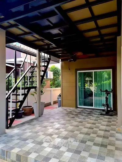 Modern covered patio with tiled flooring and staircase, ideal for outdoor relaxation and entertainment.