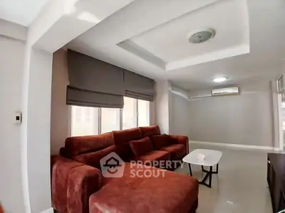 Spacious living room with modern red sofa and natural light