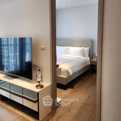 Modern bedroom with stylish decor and sleek TV setup, perfect for urban living.
