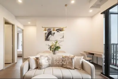 Elegant modern living room with stylish decor and open layout, featuring a cozy sofa and dining area.