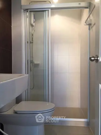 Modern bathroom with glass shower enclosure and sleek fixtures.
