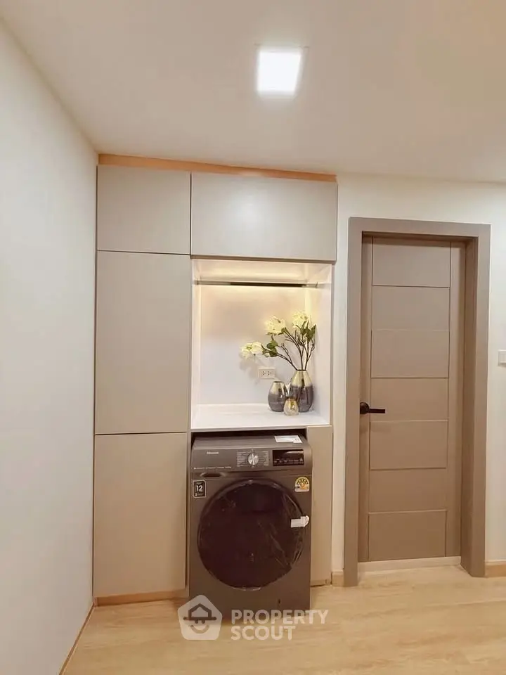 Modern laundry area with built-in cabinets and washing machine