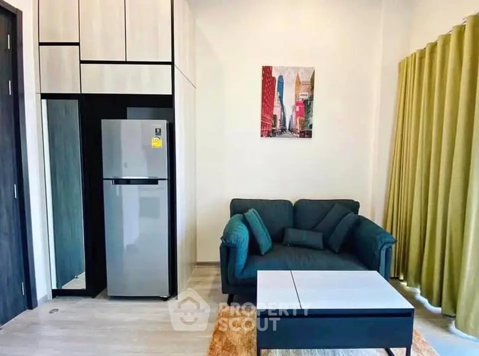 Modern living room with stylish sofa, sleek fridge, and contemporary decor in a cozy apartment.