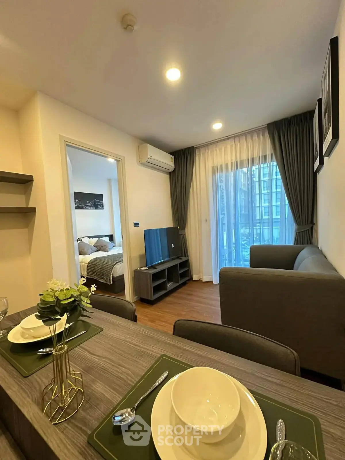 Modern living room with cozy seating and dining area, featuring elegant decor and natural light.
