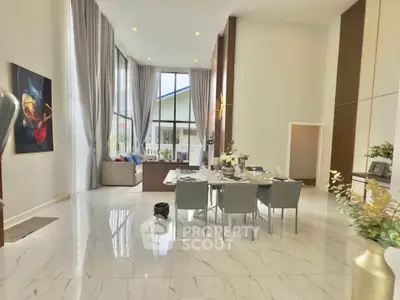 Luxurious open-plan living and dining area with high ceilings and elegant decor.