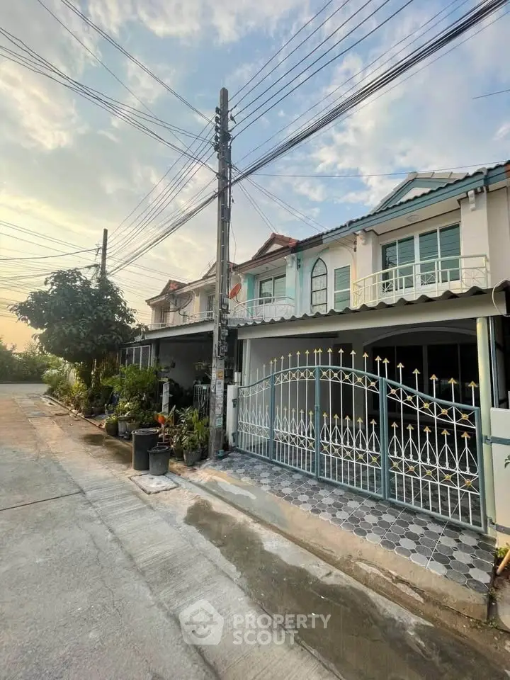 Charming townhouse with gated entrance and lush greenery in a serene neighborhood.