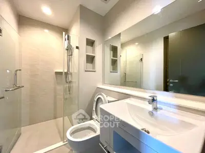 Modern bathroom with glass shower and sleek fixtures in a contemporary home.