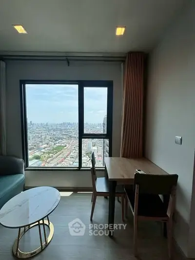 Stunning city view from modern apartment living room with cozy dining area.