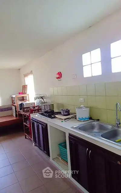 Spacious kitchen with modern sink and ample counter space in a bright, airy home.