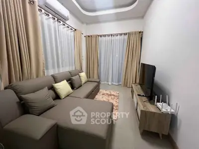 Cozy living room with modern sofa and entertainment unit, perfect for relaxation.