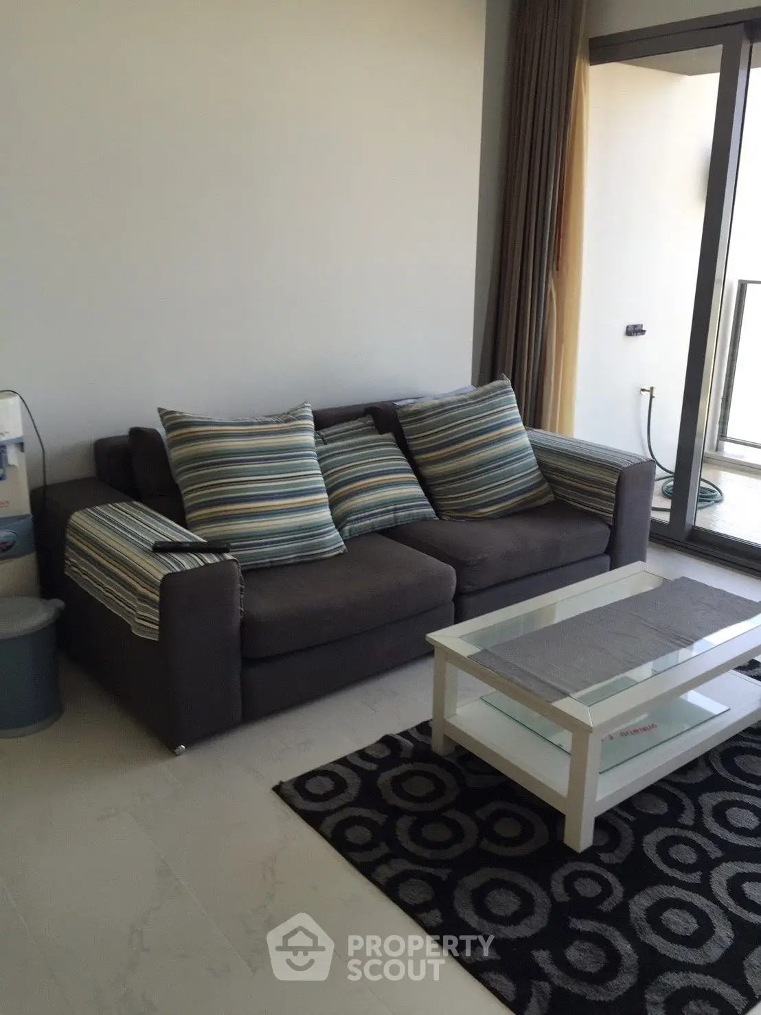 Modern living room with stylish sofa and glass coffee table in a cozy apartment.