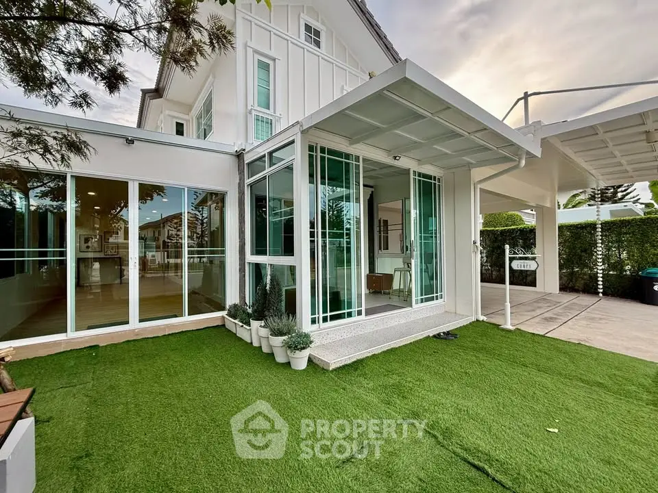 Modern house with glass extension and artificial grass lawn