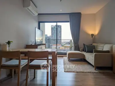 Modern living room with city view, featuring cozy sofa, dining table, and large window leading to balcony.