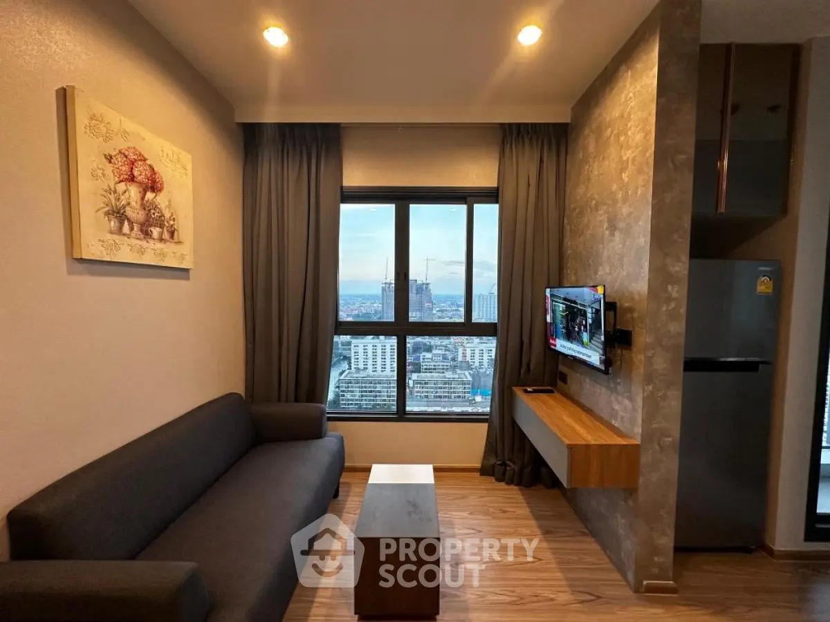 Modern living room with city view, sleek furniture, and wall-mounted TV in stylish apartment.